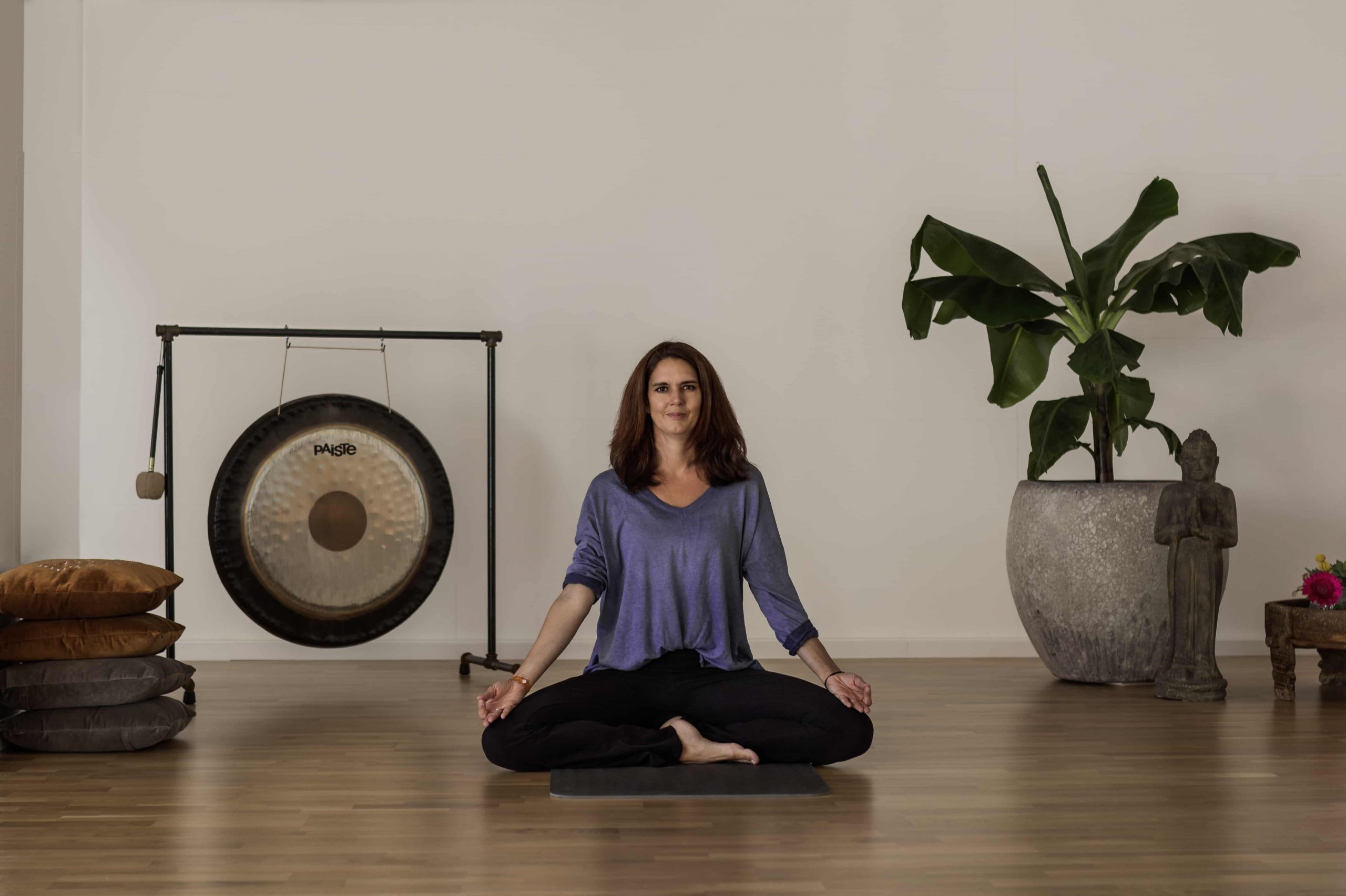 Simone Mülbert meditiert im Yoga-Studio neben einem Gong